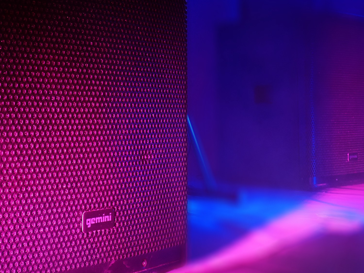 Closeup of Gemini Sound speakers with pink and blue stage lights