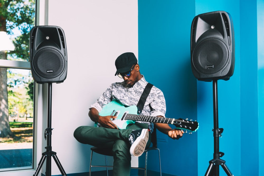 man playing guitar with Gemini Sound speakers